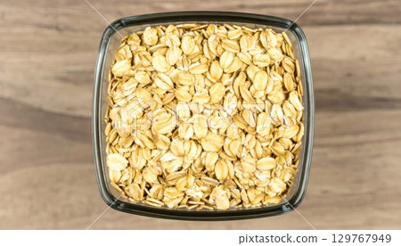 Dry raw organic oatmeal and buckwheat cereal grains in glass jars on a white background 129767949