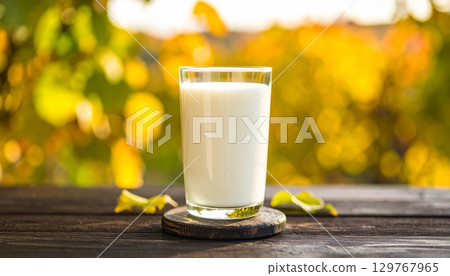 Glass of cold, fresh milk on a wooden table Glass of cold, fresh milk on a wooden table 129767965