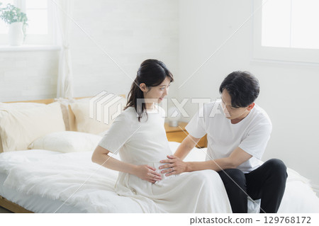 Pregnant couple in the bedroom Pregnant couple in the bedroom 129768172