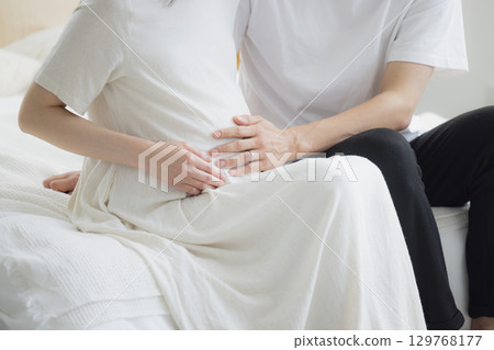 Pregnant couple in the bedroom 129768177