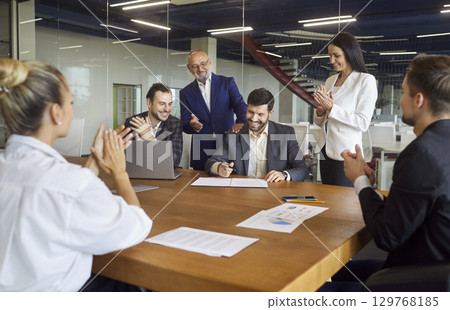 Business people sitting together at table with papers, making project, discussing sale statistics 129768185
