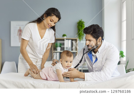 Pediatrician examining cute little baby with stethoscope lying on couch in medical clinic 129768186