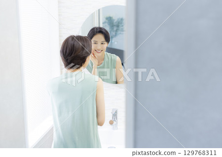 一位女士在浴室裡做皮膚護理 129768311