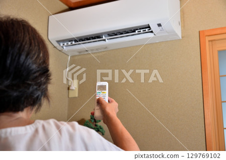 操作空調的高級女士 129769102