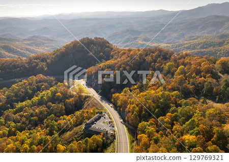 Freeway road with fast moving traffic cars and trucks in North Carolina Appalachian mountains in fall season. Interstate transportation infrastructure in USA 129769321