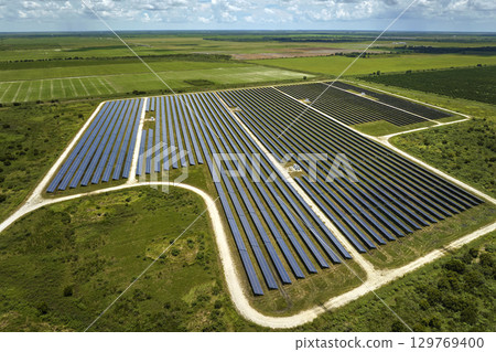 Aerial view of big sustainable electric power plant with many rows of solar photovoltaic panels for producing clean electrical energy. Renewable electricity with zero emission concept 129769400