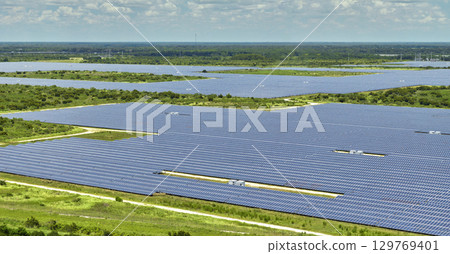 Aerial view of large sustainable electrical power plant with rows of solar photovoltaic panels for producing clean electric energy. Concept of renewable electricity with zero emission 129769401