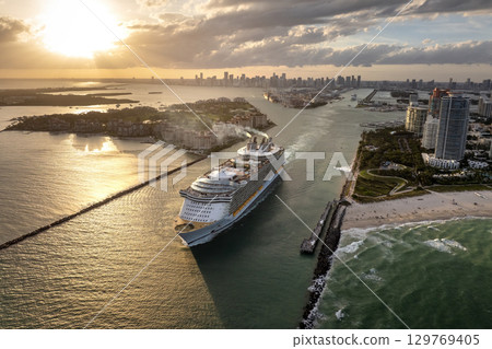 Big passenger cruise liner ship departing at main channel in Miami harbor near South Beach high luxurious hotels and apartment buildings 129769405