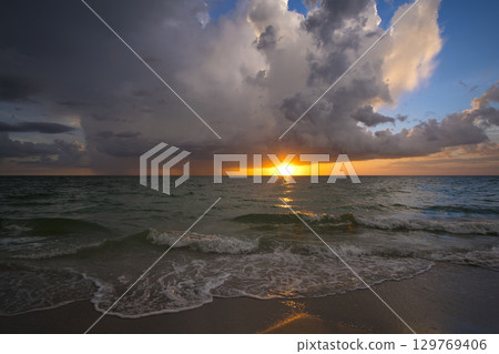 Heavy rain falling down over dark ocean at sunset. Extreme Florida weather in hurricane season 129769406