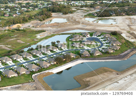 Gated community with expensive houses between green palm trees in southwest Florida. Premium housing development in the USA Gated community with expensive houses between green palm trees in southwest Florida. Premium housing development in the USA 129769408
