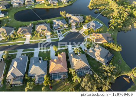 View from above of residential houses in living area in North Port, FL at evening. Illuminated American dream homes as example of real estate development in US suburbs View from above of residential houses in living area in North Port, FL at evening. Illuminated American dream homes as example of real estate development in US suburbs 129769409