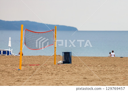 Empty volleyball net on a sandy beach on the sea shore in summer. 129769457