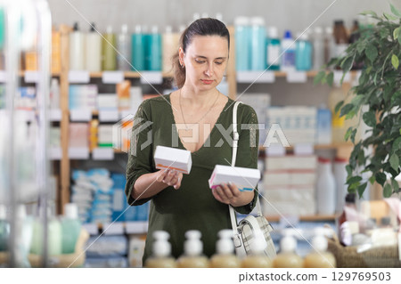 Woman are busy choosing tablet box at pharmacy 129769503