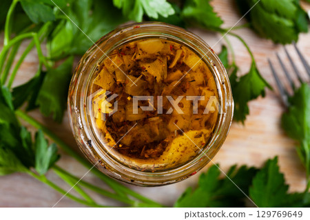 Glass jar with pickled herring and parsley on wooden table Glass jar with pickled herring and parsley on wooden table 129769649