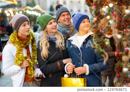 Family of four choosing decorations at Christmas fair 129769671
