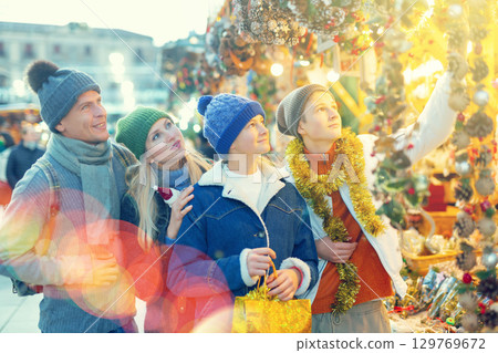 Family of four choosing decorations at Christmas fair 129769672