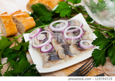 Salted herring fillet with onion 129769729