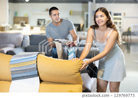 Newlyweds choose upholstered furniture in store 129769773