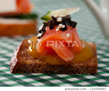Canape with salmon and mango sauce 129769801