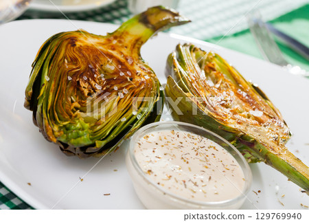 Appetizing artichokes grilled with coarse salt 129769940