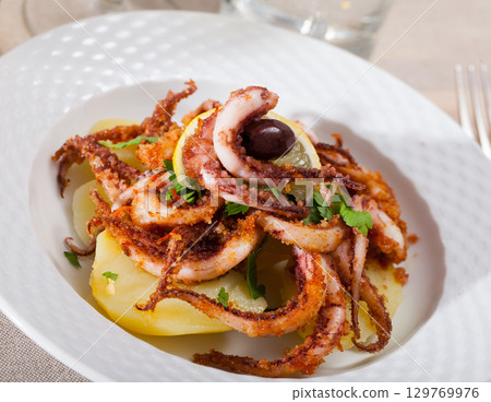 Fried tentacles squid with potatoes Fried tentacles squid with potatoes 129769976