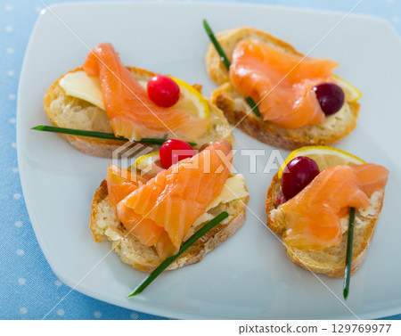 Tapas with salmon, lemon, cranberry Tapas with salmon, lemon, cranberry 129769977