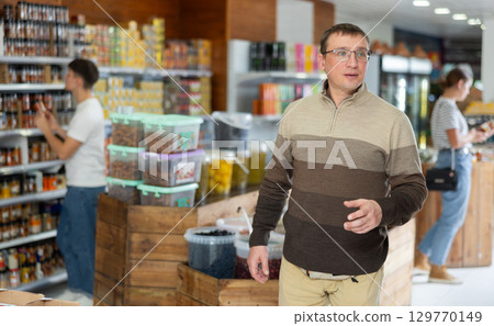 Middle aged man looking for necessary products in supermarket 129770149