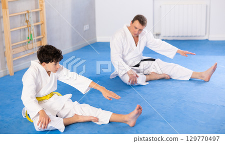 Man and boy teenager doing stretching in studio 129770497