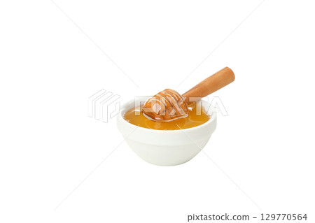 Honey drips from a wooden dipper into a bowl, isolated on white, PNG 129770564