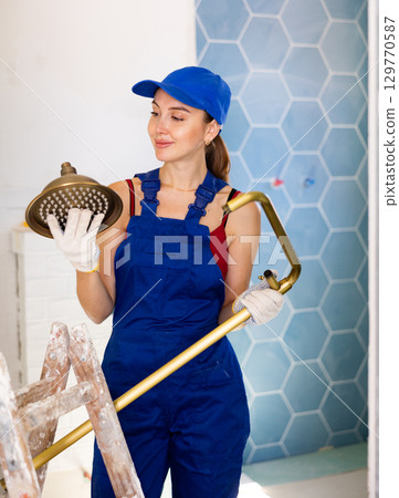 Female builder posing with new shower in bathroom being renovated Female builder posing with new shower in bathroom being renovated 129770587