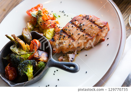 Grilled tuna steak with salad of tomatoes and avocado Grilled tuna steak with salad of tomatoes and avocado 129770735