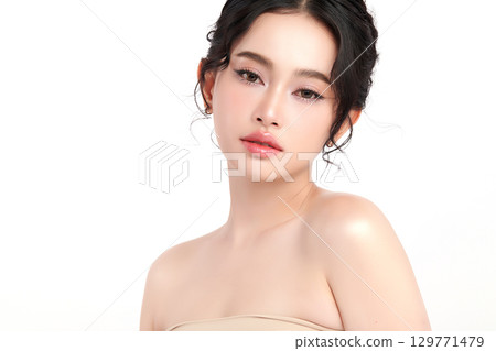 A beautiful young Asian woman with clean, fresh skin against a white background. Skincare, facial treatment, cosmetology, beauty, and spa. An elegant portrait of an Asian woman. 129771479