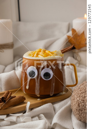 Funny halloween decoration face with eyes on cup of Pumpkin spiced latte morning warming coffee. Fall Drinks for Halloween Thanksgiving Holiday beverage Autumn spicy cinnamon flavor seasonal hot 129771545
