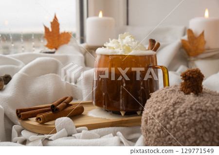 Seasonal drink cacao coffee with whipped cream and cinnamon sticks Thanksgiving and Hello Fall Halloween concept. Celebrating autumn holidays at cozy home on the windowsill atmosphere Autumn leaves 129771549