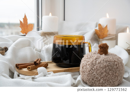 Hand adds whipped cream Autumn hygge Orange Cup of warm coffee autumn leaves on table against raindrops are running down the glass in window. Cozy fall still life footage burning candles. Thanksgiving Hand adds whipped cream Autumn hygge Orange Cup of warm coffee autumn leaves on table against raindrops are running down the glass in window. Cozy fall still life footage burning candles. Thanksgiving 129771562