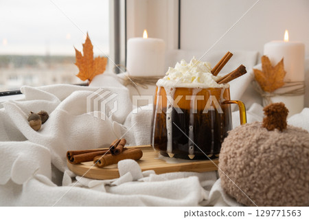 Seasonal drink cacao coffee with whipped cream and cinnamon sticks Thanksgiving and Hello Fall Halloween concept. Celebrating autumn holidays at cozy home on the windowsill atmosphere Autumn leaves 129771563