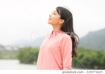 一名女子站在公園的水邊 129771625