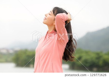 一名女子站在公園的水邊 129771626