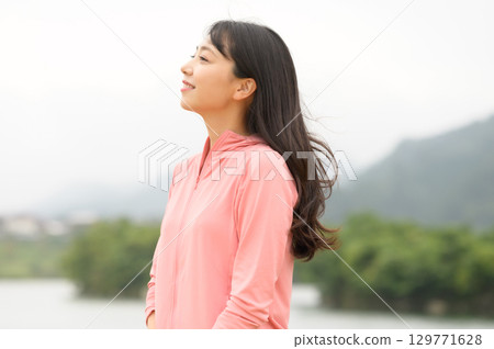 一名女子站在公園的水邊 129771628