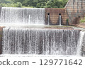 An artificial, long waterfall that regulates the flow of a river 129771642