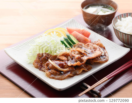 A freshly cooked piping hot pork shogayaki set meal featuring steaming juicy pork and cabbage for a Japanese lunch. 129772090