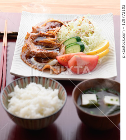 新鮮烹製的熱氣騰騰的豬肉燒套餐，以熱氣騰騰的多汁豬肉和捲心菜為特色，是日式午餐。 129772102