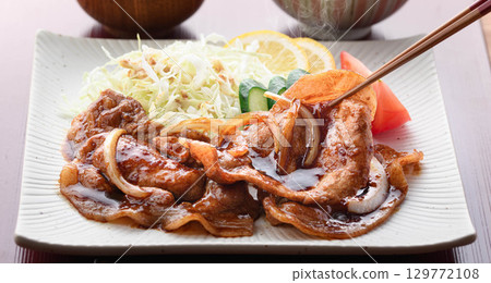 A freshly cooked piping hot pork shogayaki set meal featuring steaming juicy pork and cabbage for a Japanese lunch. A freshly cooked piping hot pork shogayaki set meal featuring steaming juicy pork and cabbage for a Japanese lunch. 129772108