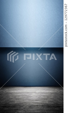 Interior of a modern and minimalist studio with a blue wall and dark floor background. Mockup or copy space 129772367
