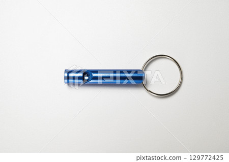 Closeup view of a blue whistle isolated over a white background 129772425