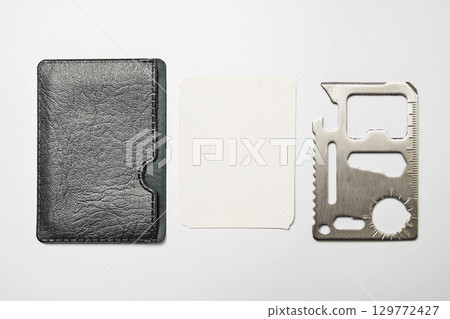 Minimalist leather wallet with blank card and stainless steel multi tool isolated over a white background. Mockup or Copy space Minimalist leather wallet with blank card and stainless steel multi tool isolated over a white background. Mockup or Copy space 129772427