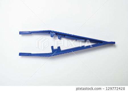 Closeup view of blue plastic forceps or a tweezer tool isolated over a white background Closeup view of blue plastic forceps or a tweezer tool isolated over a white background 129772428