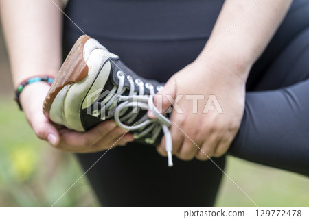 Overweight woman in a sporty outfit practices exercise in a public park outdoors. Concept of a Healthy active lifestyle and body inclusivity 129772478