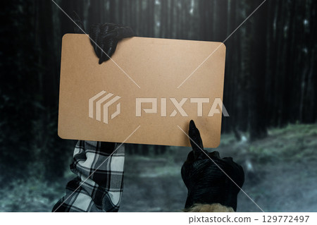 Werewolf hands showing a piece of brown paper with a night scene background. Monster, devil, evil, satan, or zombie hands. Mockup or Copy space. Concept of Spooky Halloween 129772497