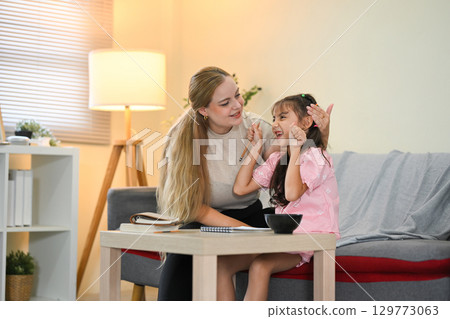 Parent supporting child learning and development through homework help 129773063